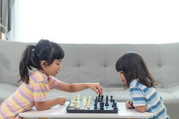istock Little sibling girl playing chess at home. 1453767748