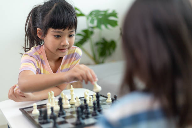 istock Little sibling girl playing chess at home. 1453767778