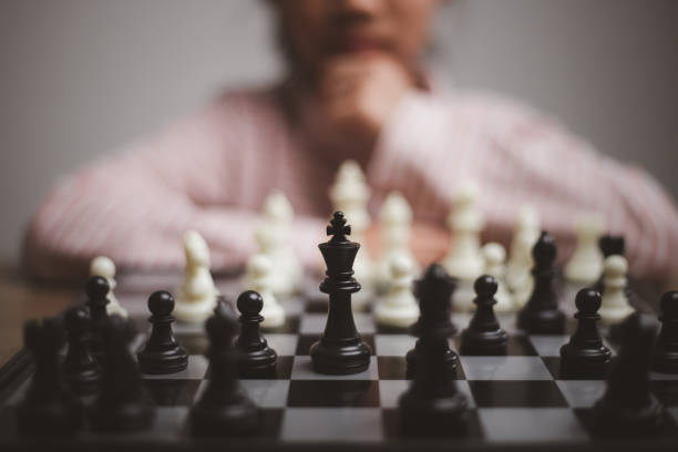 niña jugando una partida de ajedrez en un tablero de ajedrez. - chess skill concentration intelligence fotografías e imágenes de stock