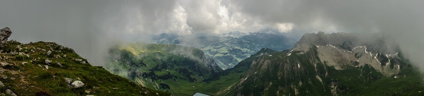 A panoramic shot of a landscape during the day under the clouds