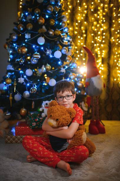istock Beautiful smiling little boy near Christmas tree 1453769174