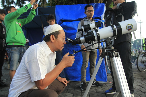 Yogyakarta, Indonesia, March 9, 2016. With binoculars, a citizen witnesses the natural phenomenon of a total solar eclipse.