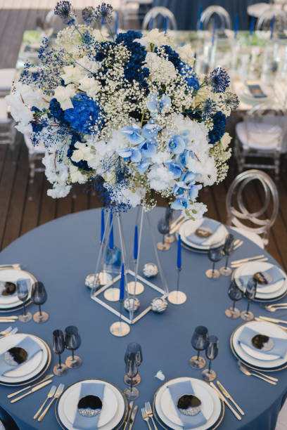istock Table setting at the wedding reception. Floral compositions with beautiful flowers and greenery, candles, laying and plates on a decorated table. 1453783468