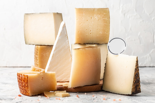 Cheese board of various types of soft and hard cheese. spanish manchego cheese, International dairy delicacies. vertical image.