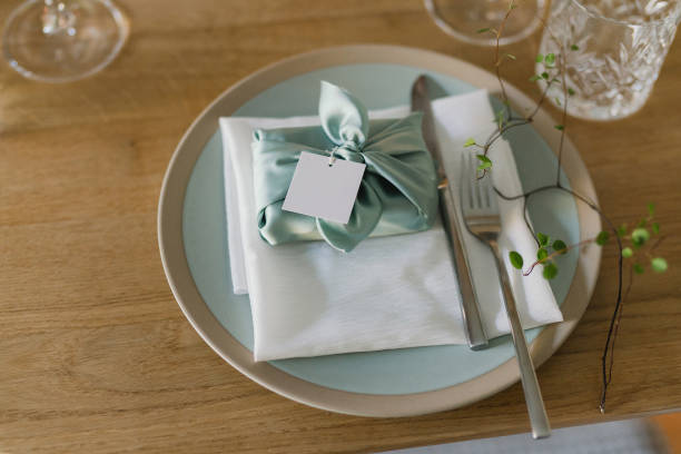 istock Table setting at the wedding reception. Floral compositions with beautiful flowers and greenery, candles, laying and plates on a decorated table. 1453784853
