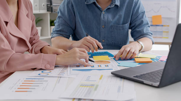 istock Closeup hand asia people small team talk work on SEO paper chart graph data reskill upskill class hybrid office course. Asian man woman sharing job career idea advice budget report project on laptop. 1453785075