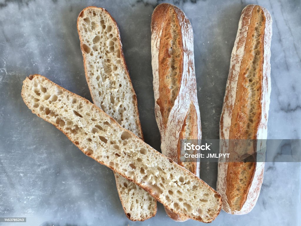 Traditional rustic bread bird's eye view of three loaves of bread, one of which is cut in half and allows you to see the crumb of bread. Backgrounds Stock Photo