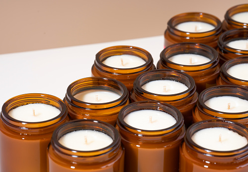 A set of different aroma Soy wax candles in brown glass jars. Scented calming candle. Natural essential candles in a Amber jar. Tendy concept diy. Vegan product. Isometric diagonal protection.
