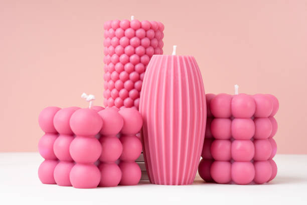 istock Handmade olive wax different forms pink color candle on a duotone pastel pink and white background. Sustainability vegan candle, natural materials. Minimalistic, modern photo. Copy space. Close up. 1453787080