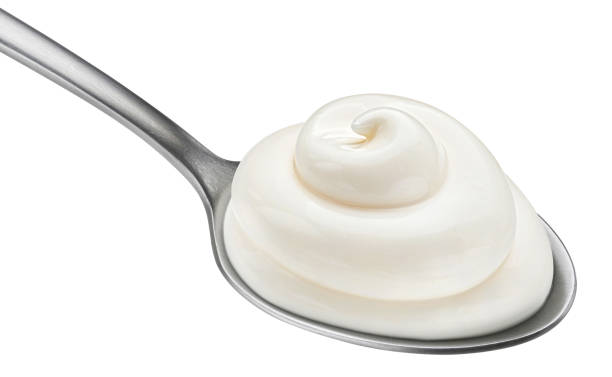 istock Sour cream in spoon isolated on white background 1453788273