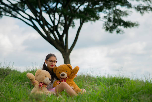 Young woman outdoors in her favorite hobbies, reading, enjoying and playing guitar.