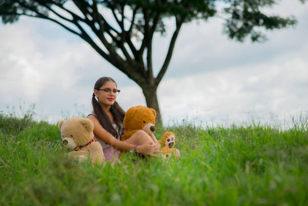 Young woman outdoors in her favorite hobbies, reading, enjoying and playing guitar.