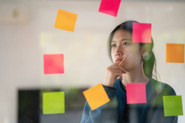 istock Young confident Businesswoman planning with adhesive notes in creative office. 1453789924