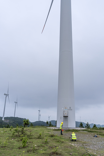Two engineers work in front of the wind power plant