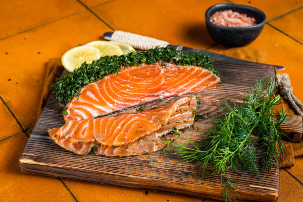 filete de salmão escandinavo gravlax com endro, sal e papper. fundo laranja. vista superior - gravlax - fotografias e filmes do acervo