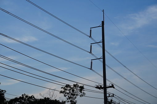 Concrete Electricity  post with high voltage wire on blue sky background