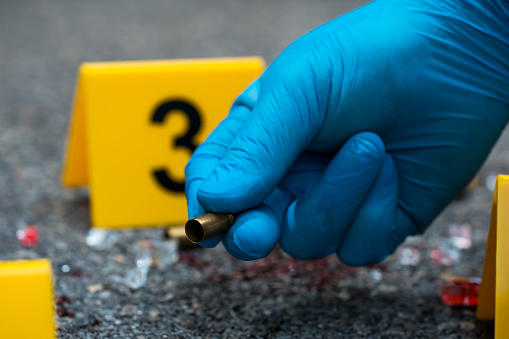 Bullet casing on asphalt. Crime scene investigation.