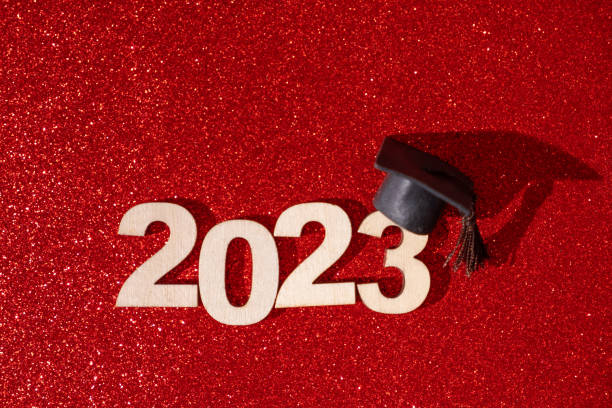 istock Class of 2023 concept. Numbers 2023 with black graduated cap on glitter red background 1453800523