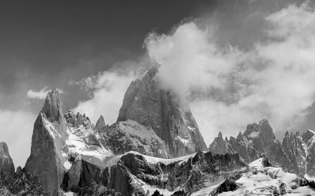 istock Scenic black and white view of rocky peaks covered with clouds 1453803786