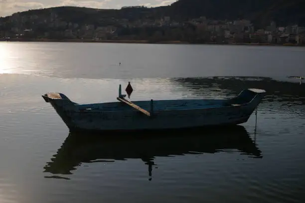 An old wooden fishing boat on a lake in Kastoria, Greece