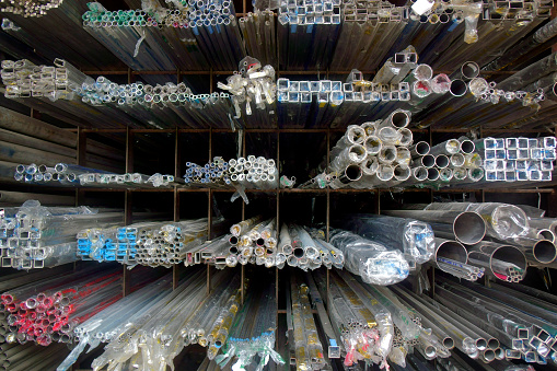 Close up industrial steel products of metal profiles and tubes on warehouse shelf
