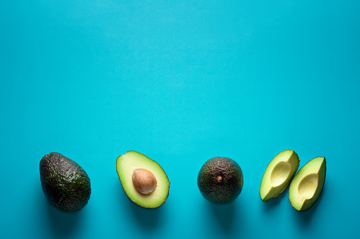 Fresh avocados on a blue background. Banner with free space for text. Healthy Eating.