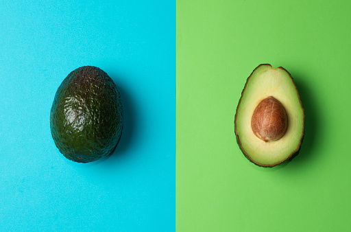 Fresh avocados on a blue and green background. Avocado oil in a bottle. Healthy Eating.