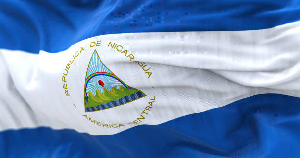 Close-up view of the Nicaragua national flag waving Close-up view of the Nicaragua national flag waving. It is blue, white, and blue with a national coat of arms and. Fabric textured background. Selective focus. Realistic 3d illustration flag of nicaragua stock pictures, royalty-free photos & images