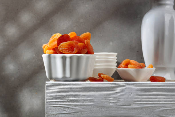 Dried apricots on a white wooden table.