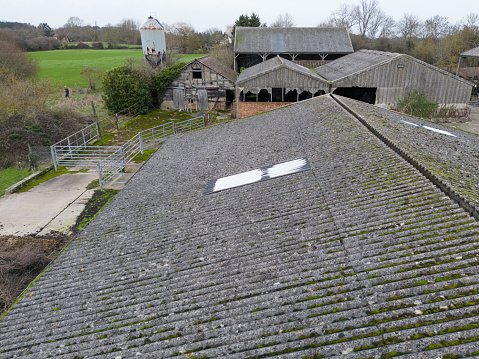 Drone view of an old asbestos roof seen on a farm building, prior to being removed. The shed is used to house livestock during the winter months.