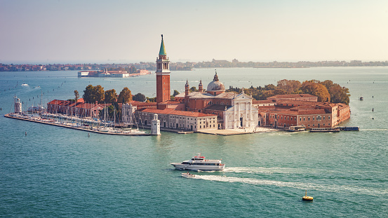 Aerial view of the island and the church of San Giorgio Maggiore from the bell tower (from the Campanile di San Marco), in the background the island of the psychiatric hospital (now converted into a museum) and the Lido islands. Venice, Italy