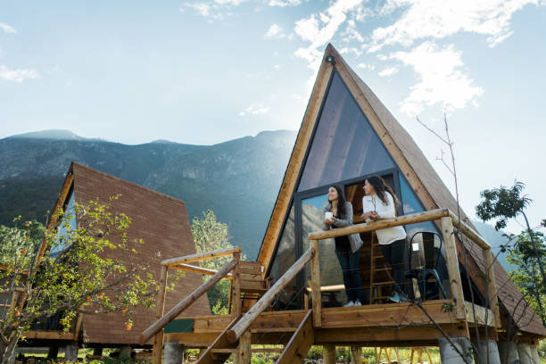 deux amies dégustent une boisson chaude à l’extérieur de la cabine - maison de vacances photos et images de collection