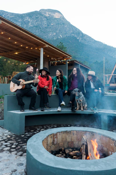 istock Young people singing and eating marshmallows in campsite 1453815012