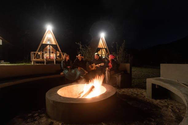 istock Young people sitting around campfire at night 1453815042