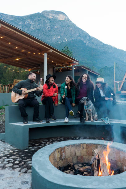 istock Young people singing and laughing outside around campfire 1453815044