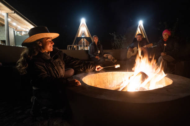 istock Young latin people sitting around campfire at night 1453815047