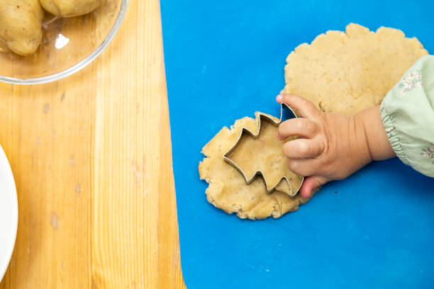 istock Toddler making shapes with play dough using rolling pin 1453817527