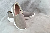 A pair of new gray slip-ons, for women.