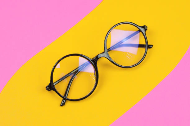 istock Stylish round glasses on a colored background with palm leaves 1453820571