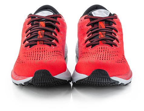 A pair of red running shoes. \nIsolated on a white background.