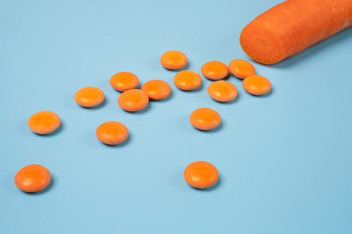 a diced carrot and some orange vitamin D pills