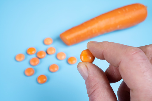 a diced carrot and some orange vitamin D pills
