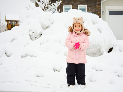 A little girl enjoying winter playing in fresh snow.