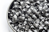 A pack full of sharp metal diabolo pellets, steel pellet air gun ammo, lots of pneumatic gun ammunition, gas weapons abstract concept. Group of objects macro, detail, extreme closeup, nobody no people