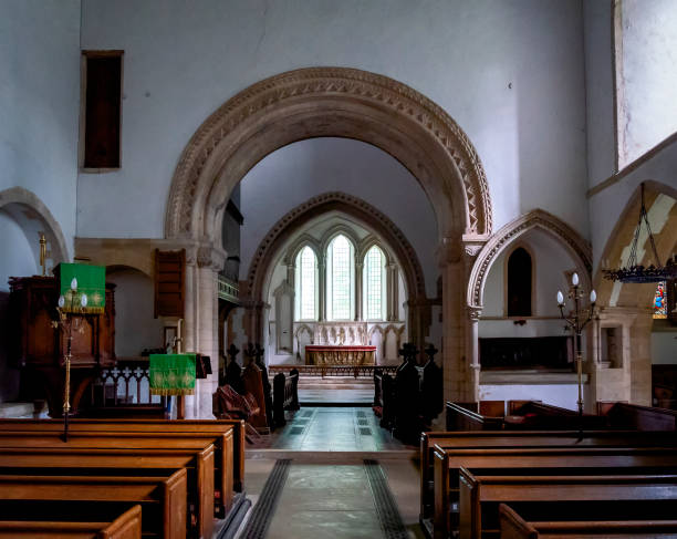 The nave and chancel of St Lawrence church in Castle Rising, Norfolk, Eastern England. St Lawrence church is a very heavily restored Norman church containing a genuine 12th century font with gleefully grinning cats’ faces. Most of the restoration was undertaken during the 19th century.