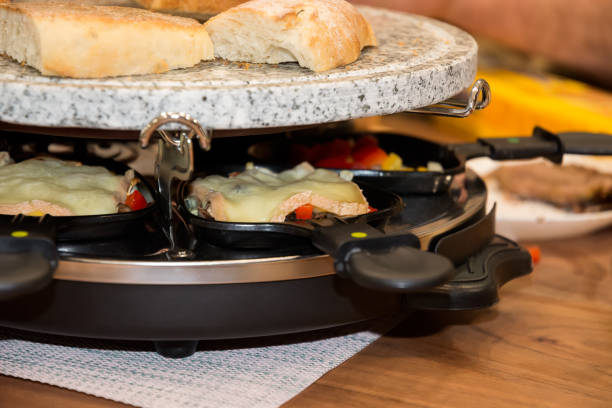 Close shot German or Dutch raclette. Entertainment, pleasant conversation and food for a large company for the new year, Silvester. stock photo