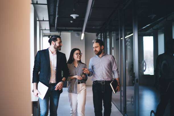 istock Cheerful employees discussing project in corridor 1453833001
