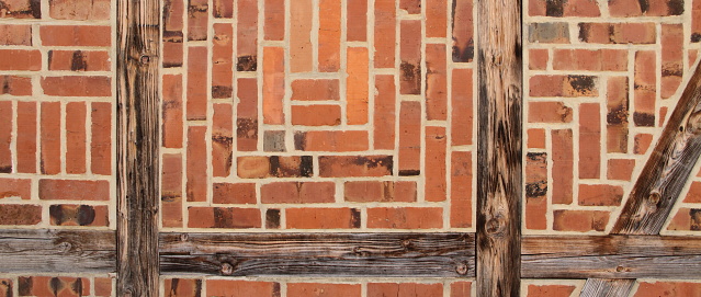 Stone wall made of bricks with wooden beams