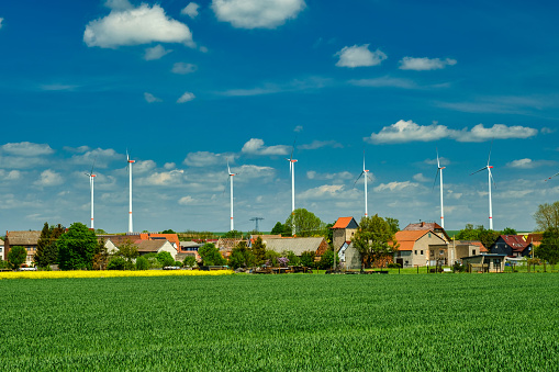 Wind electric turbines in agricultural wheat field in countryside. Deutchland.