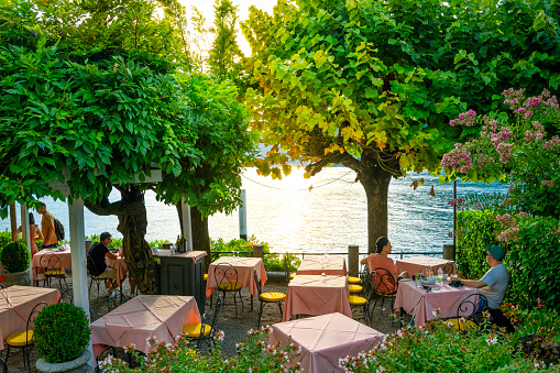 A lakefront cafe as the sun sets in Bellagio, Italy, on the shore of Lake Como. Lake Como, in Northern Italy’s Lombardy region, is an upscale resort area known for its dramatic scenery, set against the foothills of the Alps.